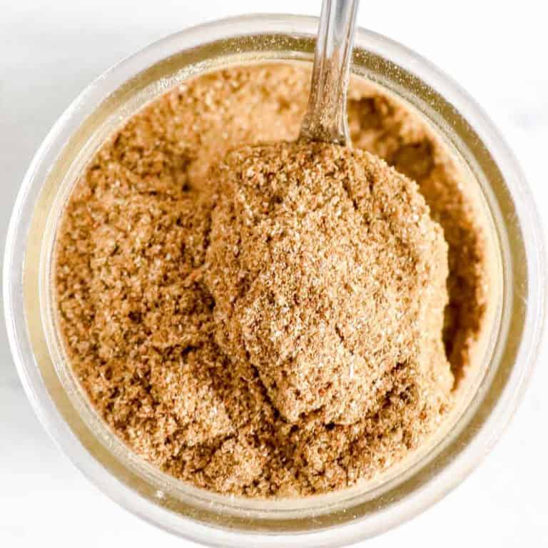 Sage Pork Rub Spices mixed together in a clear dish with a spoon being pulled out. www.atwistedplate.com/sage-pork-rub/