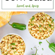 A colorful bowl of fresh yellow corn kernels mixed with diced red onions, green jalapeños, and fresh herbs in a light, honey-vinegar dressing.