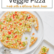 A top-down view of a rectangular pizza crust covered in a white ranch spread and topped with finely chopped red, yellow, and orange bell peppers, broccoli, and cauliflower.