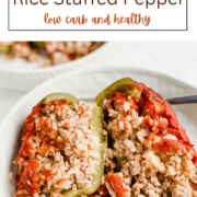 Brightly colored bell peppers stuffed with a savory mixture of ground pork, cauliflower rice, and tomato sauce, garnished with fresh herbs.